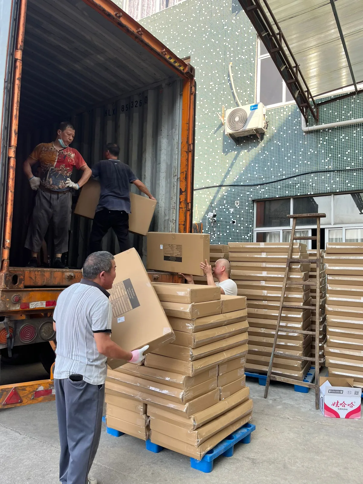 Workers loading cartons into a shipping container
