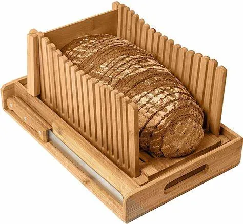 Bamboo bread slicing guide with crumb tray and a loaf of bread